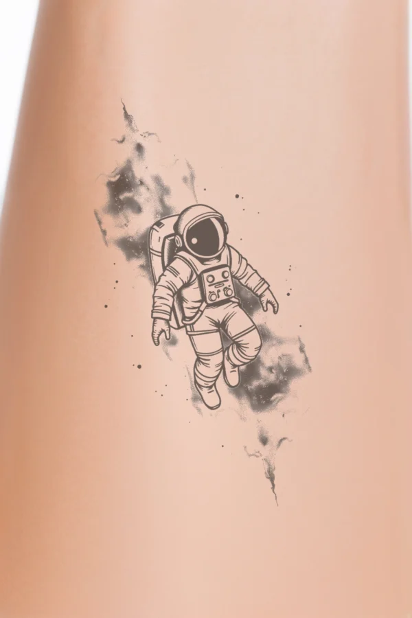 A temporary temporary tattoo design featuring a black and white illustration of an astronaut in a white spacesuit and black helmet. The astronaut floats centrally, facing right, with bent knees and feet pointed downward. Surrounding the astronaut is a smoke-like effect in shades of