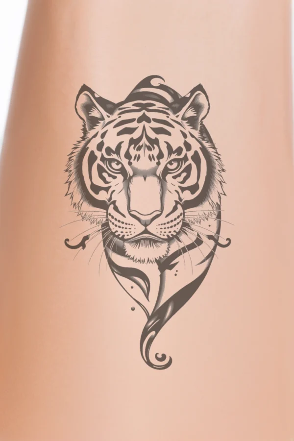 Temporary temporary tattoo featuring a realistic black and white illustration of a tiger's face. The tiger's wide-open eyes gaze forward, while its slightly open mouth reveals sharp teeth. The fur showcases intricate patterns of stripes and spots, and the prominent nose adds to its