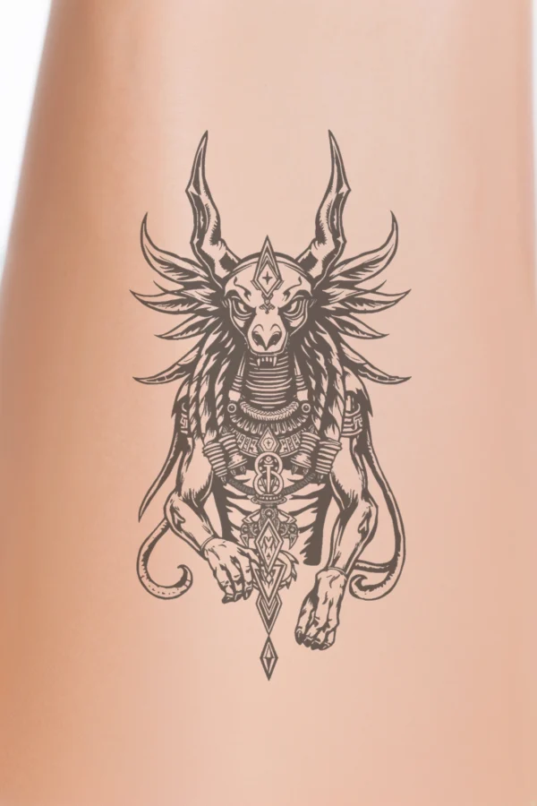 Black and white temporary temporary tattoo design featuring a fierce mythical creature, resembling a dragon or serpent. The creature has an ornate horn on its head, large expressive eyes, and an open mouth showcasing sharp teeth. Its body is intricately decorated with detailed patterns and