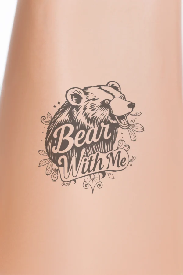 A black and white temporary temporary tattoo design featuring a bear's head and neck facing right. The bear has dark fur, slightly open mouth, visible eyes, and pointed ears. Its head is decorated with stylized leaves and flowers, enhancing the natural theme.