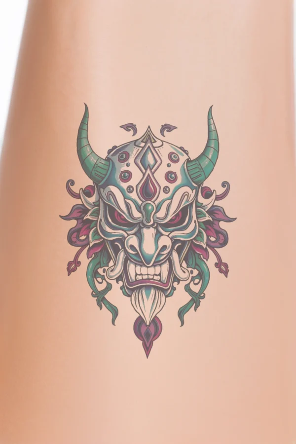 Temporary temporary tattoo design featuring a striking mask inspired by East Asian art, predominantly in white and blue. The mask has a prominent pointed nose, wide menacing grin, and striking red eyes and mouth. Intricate details include a large pointed horn on the left