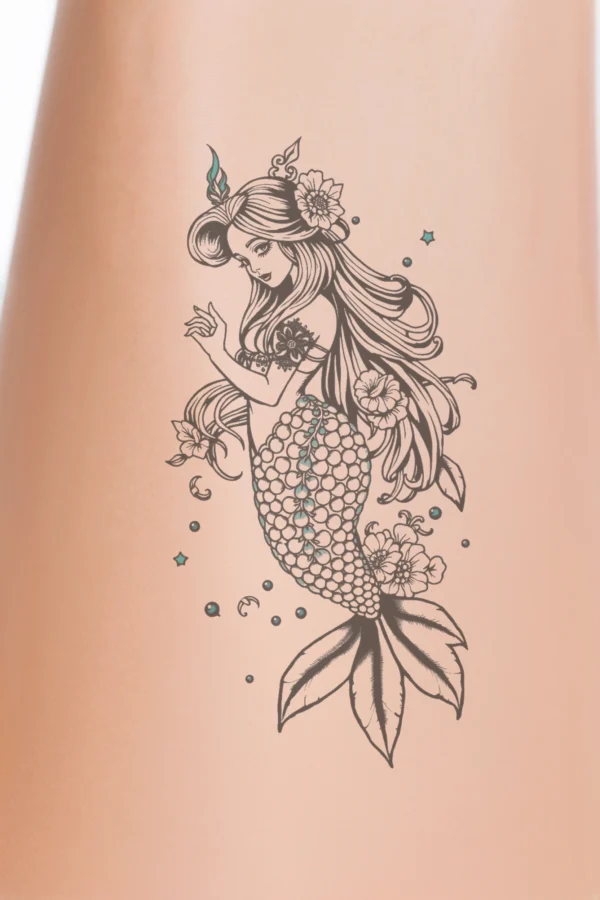 A black and white temporary temporary tattoo design featuring a stylized mermaid with long, flowing hair and a tail embellished with small, round teal-colored beads. The mermaid's face is highlighted with a pearl-like design, and she has a matching pearl-like