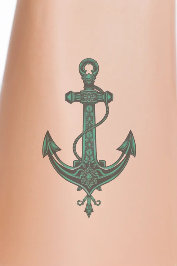 Image of a temporary temporary tattoo featuring a teal anchor at its center. The anchor, inspired by a French design, includes intricate decorative elements at the top, middle, and bottom. Set against a stark white background, the vibrant color and detailed features of the