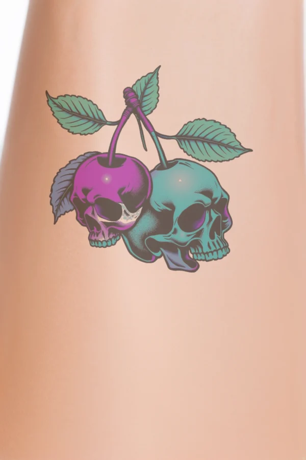 Alternative text: A temporary temporary tattoo design featuring two intertwined skulls facing each other. The left skull is a vibrant deep pink, while the right skull is a cool blue. Both skulls are embellished with green leaves that add a natural element to the temporary tattoo