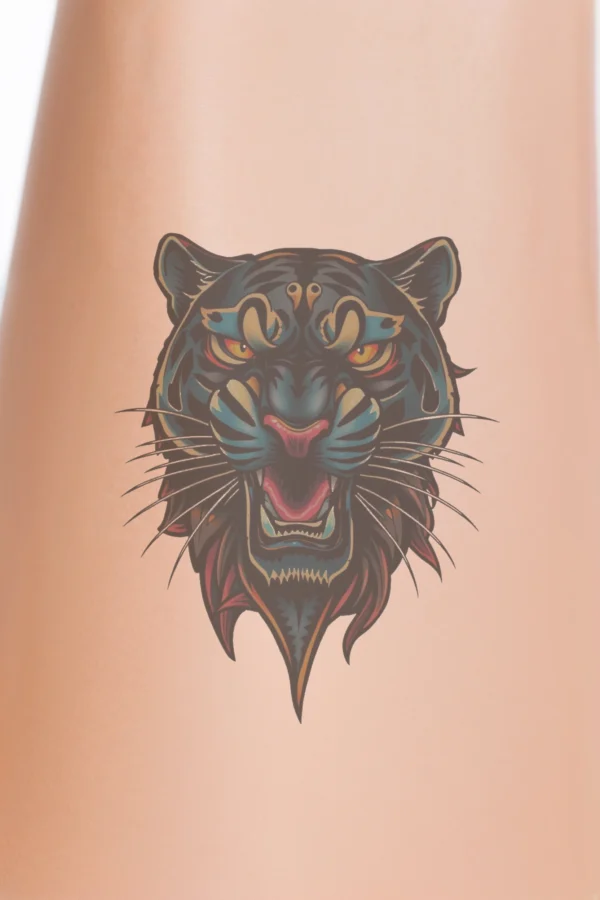 A bold temporary temporary tattoo design featuring a black panther's head, illustrated from the front. The panther's fierce expression showcases an open mouth in a roar, with striking orange eyes and a dark nose. Its fur blends shades of black and orange,