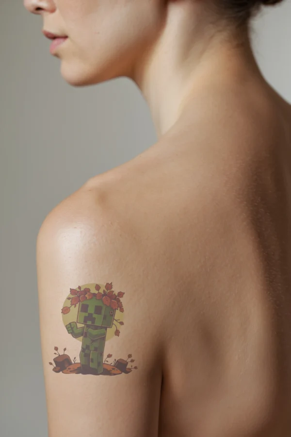 A profile view of a person showcasing a temporary temporary tattoo on their shoulder. The temporary tattoo features a cartoonish Minecraft character with a green pixelated body and a dark green head, displaying a black pixelated face. The character stands on a rocky surface with slightly