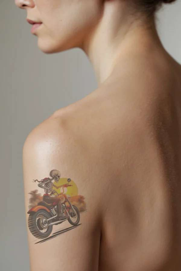 Alternative text: "Profile view of a person's shoulder showcasing a temporary temporary tattoo of a skeleton riding a motorcycle. The skeleton wears a red bandana and sits on the left side of an orange and black motorcycle, which has a black seat and handlebars. The