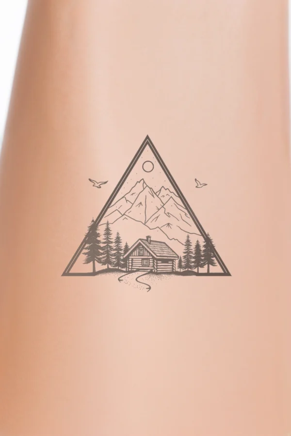 A striking black and white temporary temporary tattoo design featuring a triangular frame that contains a centrally positioned log cabin surrounded by pine trees. A winding path leads to the cabin, which is set against a stylized mountain range in varying shades of gray, adding depth.